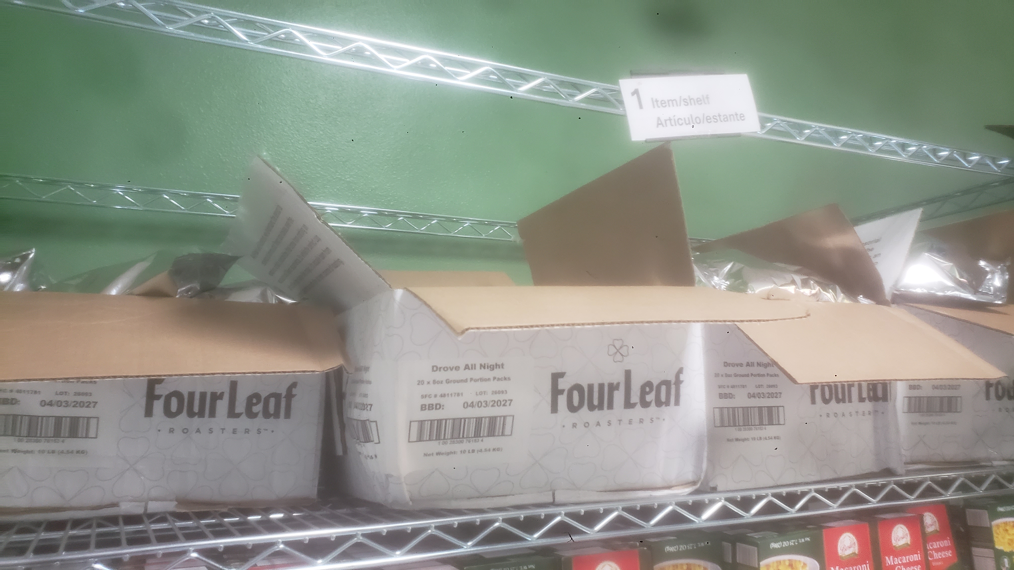 Coffee packets in cardboard boxes on a shelf.